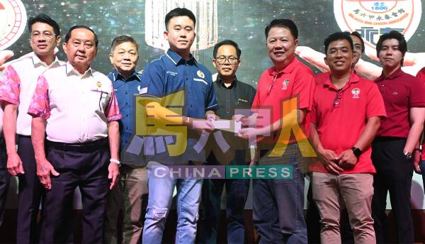 赖镶昌(前排右起)与赖乃能在刘志俍见证下,移交支票给林诗璈。
