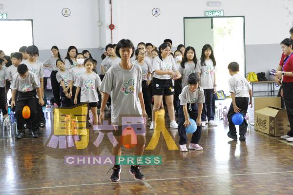 营员以双腿夹气球小心前行,既不能太用力也不能太轻,一路欢笑声连连,考验默契与控制力。