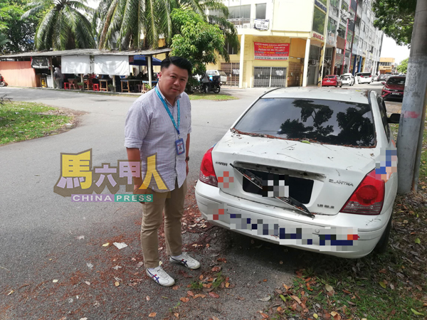 符龙川查看一辆相信弃置在路边已一段时间的汽车。