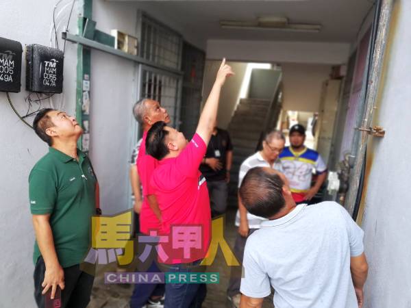 组屋管委会成员与符龙川(左2),查看组屋漏水位置。