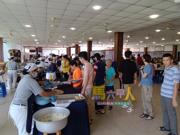 民众有秩序地排队领取素食,在欢喜与感恩中共享清净饮食。