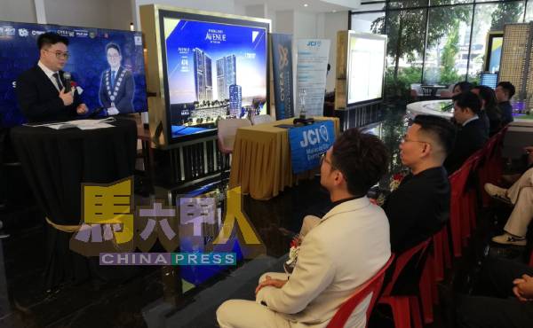 陈炜坚(左)在会上汇报国际青年商会创意青年企业家奖细节。