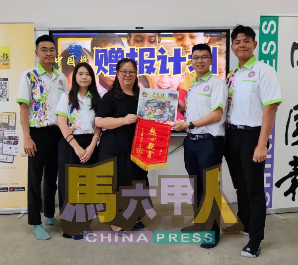 新民华小吴玉萍校长（左3起）从林文浩手中接过《中国报》，并回赠锦旗以示谢意。