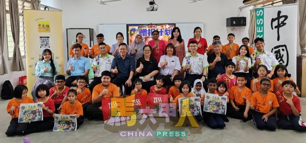 受惠学生举起《中国报》，与出席的嘉宾合照。
