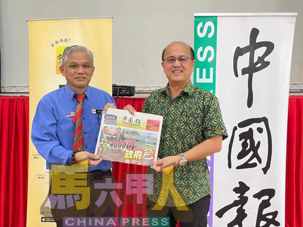 魏喜森（右）移交《中国报》给马接峇鲁华小，由薛勇建接领。