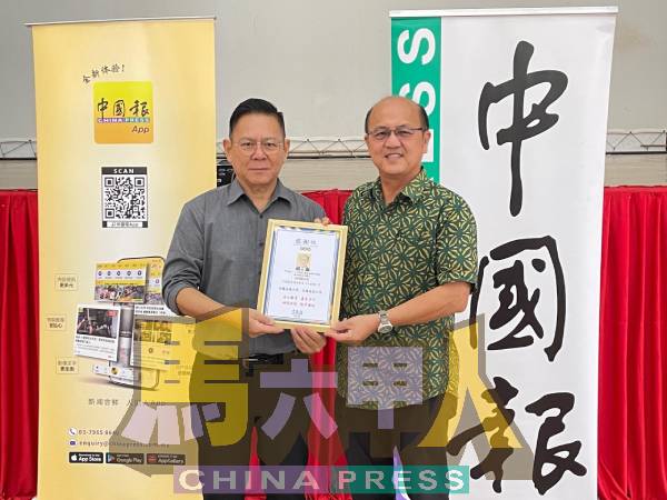 林钦为（左）赠送感谢状给魏喜森。