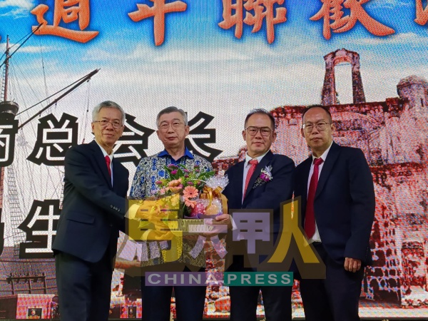 植业成（右起）、黄玉荣及冯国铨（左），代表公会联合赠送水果礼篮给吴健荣。