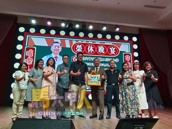 甲华小校长理事会成员在主席梁达强（左5起）带领下，赠送纪念品给韩斌元。