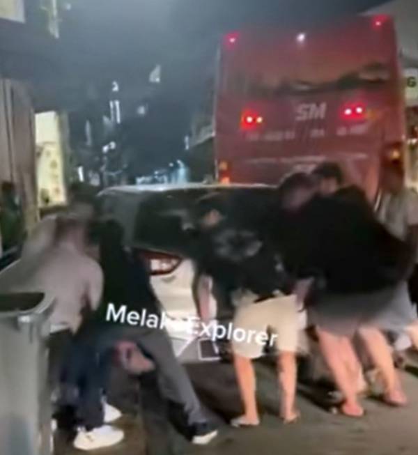数名大汉合力把阻碍交通的车辆移开。(截图自Melaka Explorer视频)