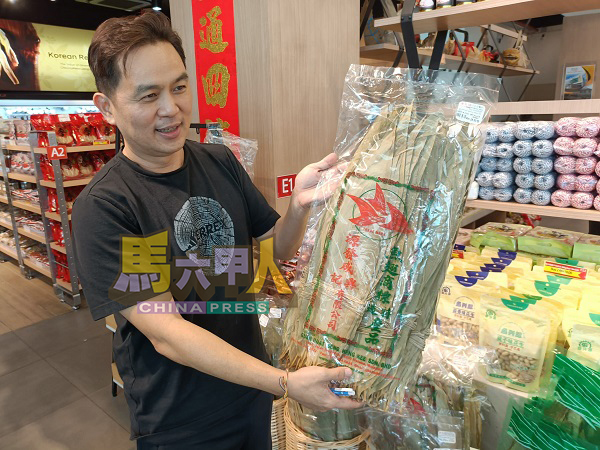 ■杨添毅展示店内所售卖10公分的包装粽叶。