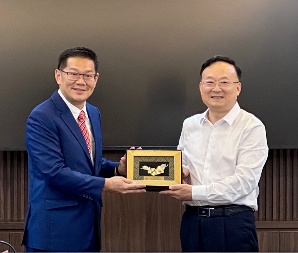 ■林万锋(左)赠送纪念品给杨树兵。