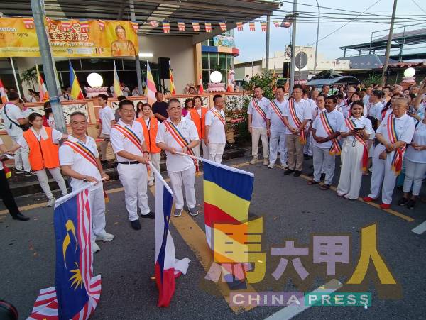 邱培栋（左起）、林万锋及孙殿赐，共同为十年一度迎佛花车大游行，进行简单不失意义的挥旗礼。