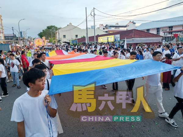 参与者手持佛旗，步步向前，以虔诚之心参与这场十年一度的佛教盛典。