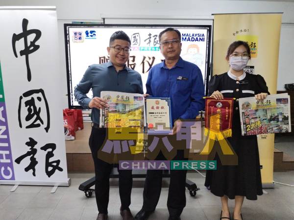 陈世荣（左起）移交《中国报》赠报给光华华小校长王隆臣及培业华小副校长韩雁珊。