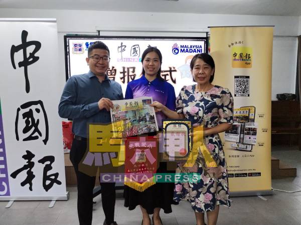 陈世荣（左起）在颜晓菁的见证下，移交《中国报》赠报给爱极乐华小校长曾慧云。