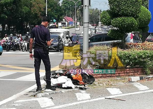 一名警员拍摄留在现场的撞毁摩哆。
