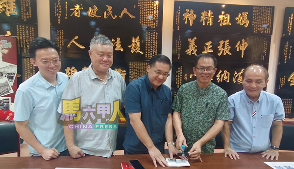 ■《老街守护者》推介礼上,刘志俍(右2)在旅游集章打卡本上盖章,右起李传财、颜天禄、蔡永泉及陈俊豪。