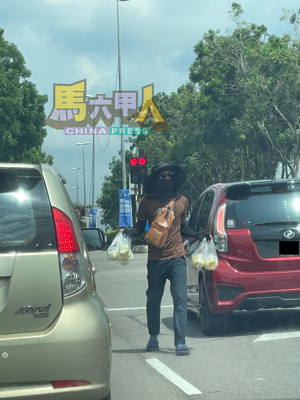 ■蒙面兜售者趁红灯亮起时,快速穿梭在车阵间,兜售饮料与腌芒果。