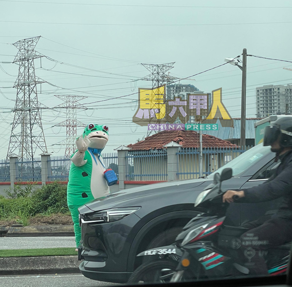 ■不明人士身穿卡通服饰,在红绿灯前对司机挥手,疑似以另类方式乞讨。