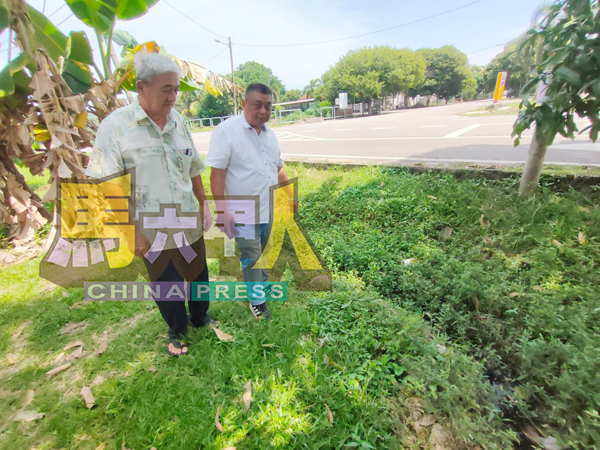 ■林应腾(左)向雷宝翔投诉排水沟旁长满杂草。
