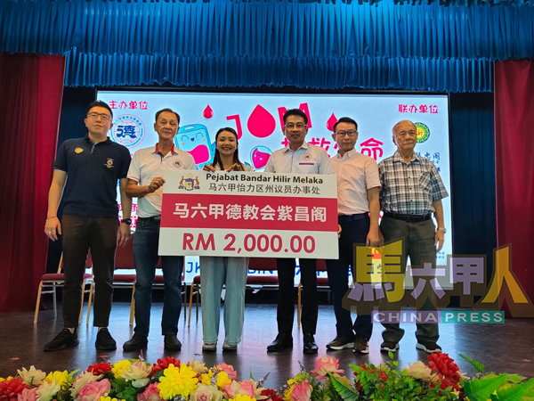 林朝雁(左3起)移交模拟支票予紫昌阁,由李献接领。左起郑立威、雷原顺;右起林斯江及李杰尔。