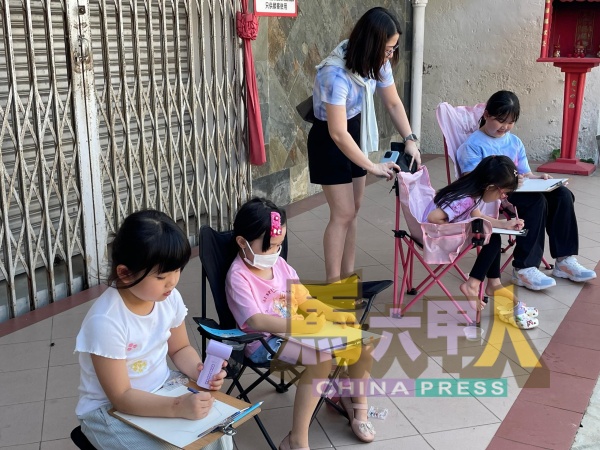 小朋友们放下手机,用心用眼,绘画充满历史痕迹的三宝井建筑物。