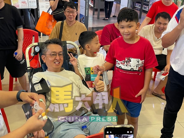孩子们为正在捐血的爸爸加油打气。