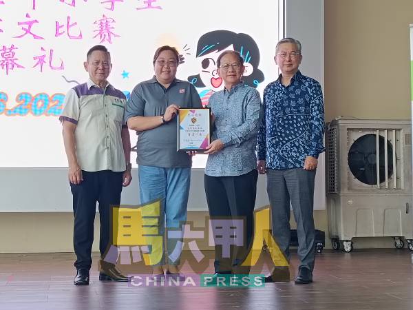 锺志兴(右起)陪同陈国源,颁发感谢状给培二华小,感谢惠借场地,由何司儿代表接领。左为林钦为。