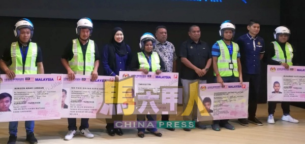 数名民众上台领取摩哆驾照模型。右4起查哈里、哈密迈丁和西蒂扎丽娜(左3)