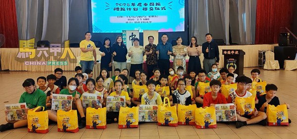 ■受惠学生举起手中的《中国报》,开心地与嘉宾们合照。