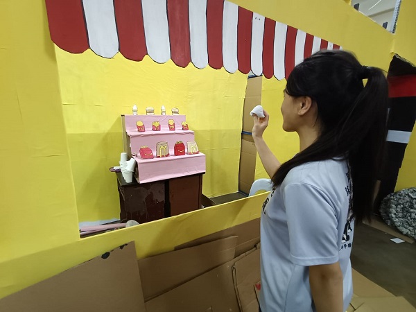 ■一名女同学手握着小沙包,并尝试投中到远处的目标。