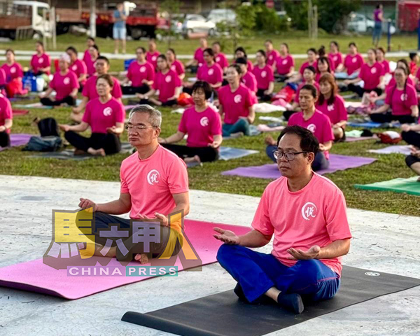 邱培栋(左)与刘志俍与民众同练瑜伽。