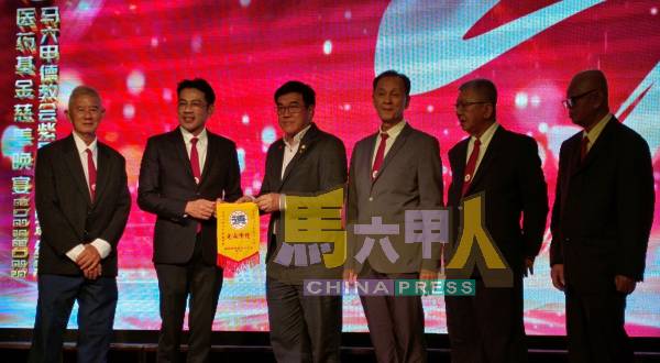 李献(左2起)代表赠送锦旗给陈宗,左起郑庆良、雷原顺、黄守群及周南奕。