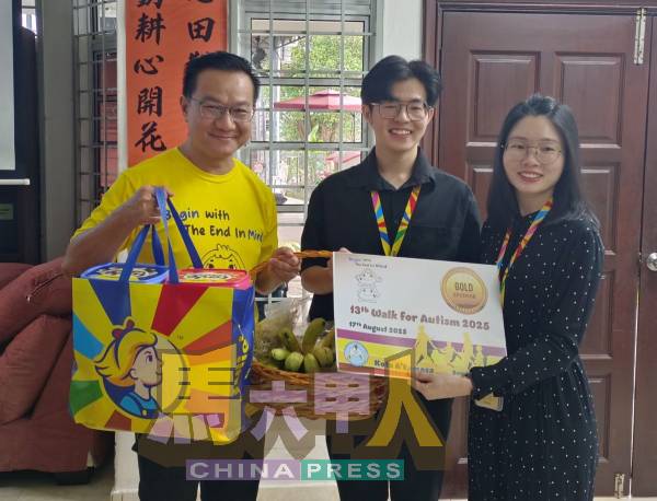 在移交赞助仪式上,余国华(左)赠送纪念品给金赞助Julie's Manufacturing Sdn. Bhd的代表。