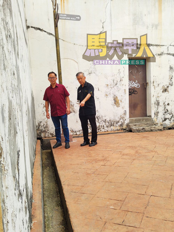■刘志俍(左)及陈劲源巡视湖海殿通往古里街的后巷沟渠。