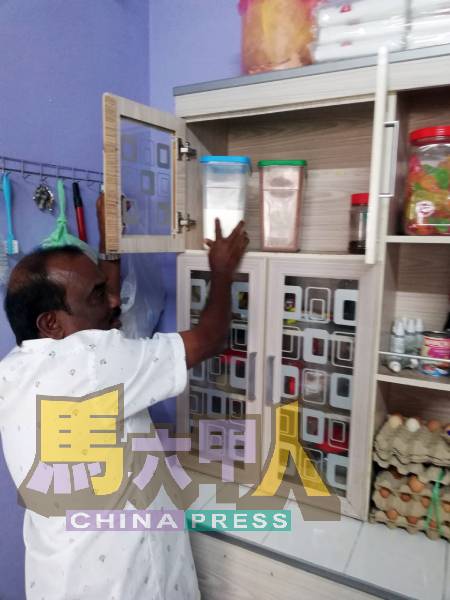 汤姆斯整理橱内的乾粮。中心每天需煮8公斤的白米和数公斤食材,让孩子都温饱。