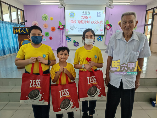 李生旺(右)颁发东方食品工业有限公司的礼袋给3位学生。