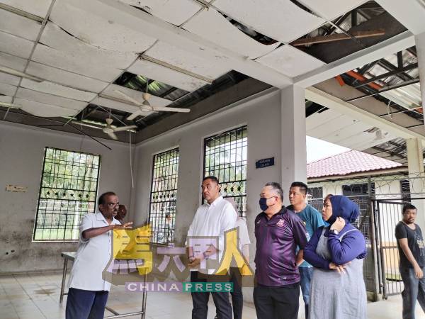 汤姆斯（左起）带领诺希尔足及陈江荣等人，察看中心极需修缮的地方。