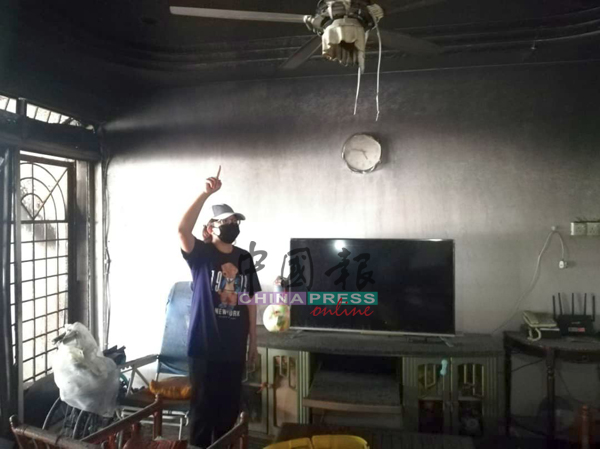 陈慧仪查看遭纵火烧毁的客厅。