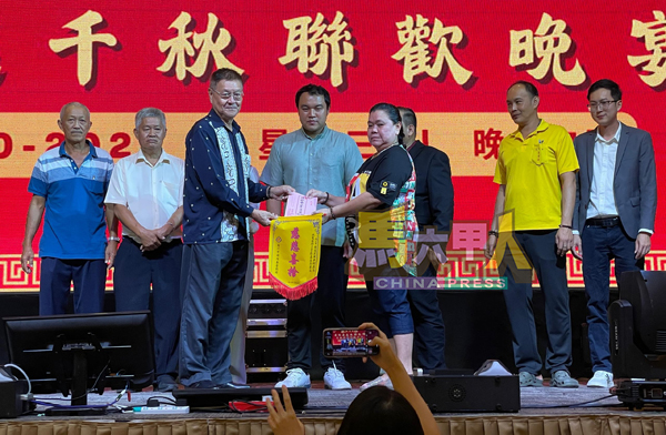 ■修德善堂福利股长吴润初(前排左)从廖美轩手中,接过500令吉善款。