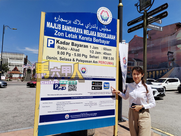 ■骆慧茹察看已修复好的泊车费缴付指示牌。