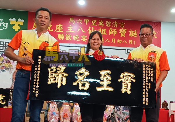 ■拿督杜彩莲（中）接领贺匾。右为赖华金，左为罗枚泰。