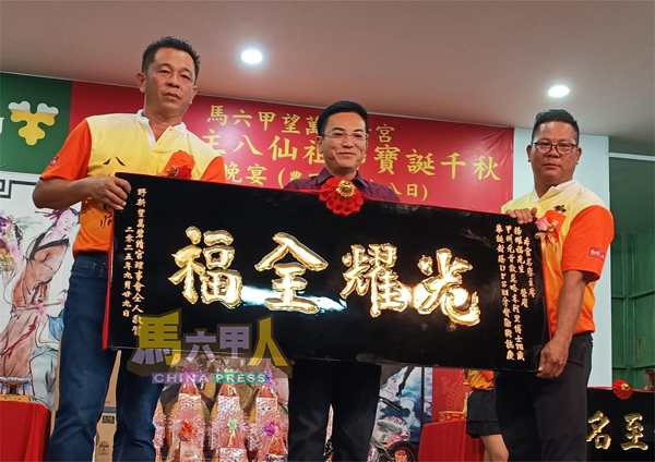 ■拿督杨耀福（中）接领贺匾。右为赖华金，左为罗枚泰。