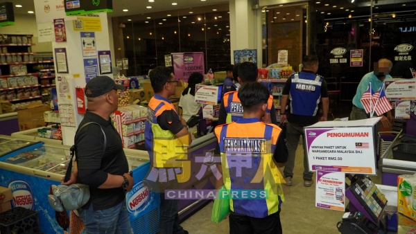 执法人员到商场察看固体废料处理情况。