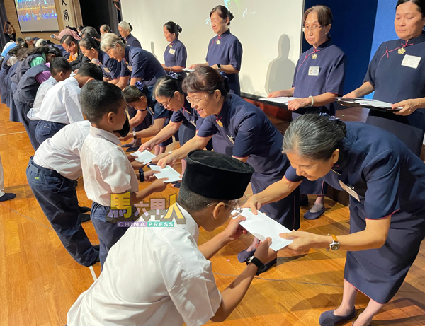 各族学生向慈济志工与嘉宾鞠躬致意后,恭领奖助学金。