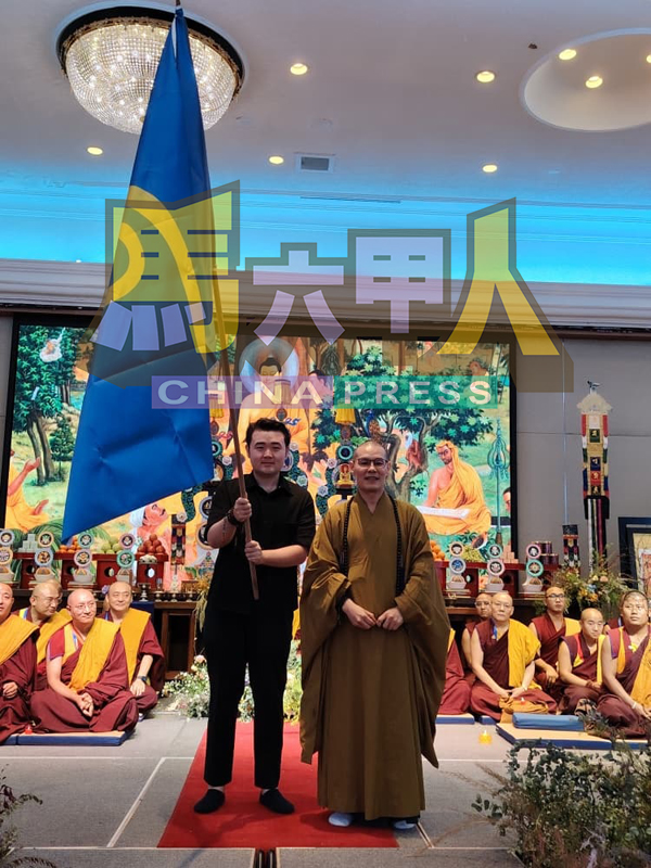 ■释宗平法师(右)移交大会旗给马来西亚莲花生命基金会拿汀斯里卢翠婷的代表熊圣。