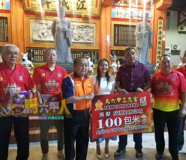 ■颜贞强（左3）代表峇章慈善基金会接领福米。左起陈念升、吴建培。右起陈江荣、诺希尔米、林朝雁。